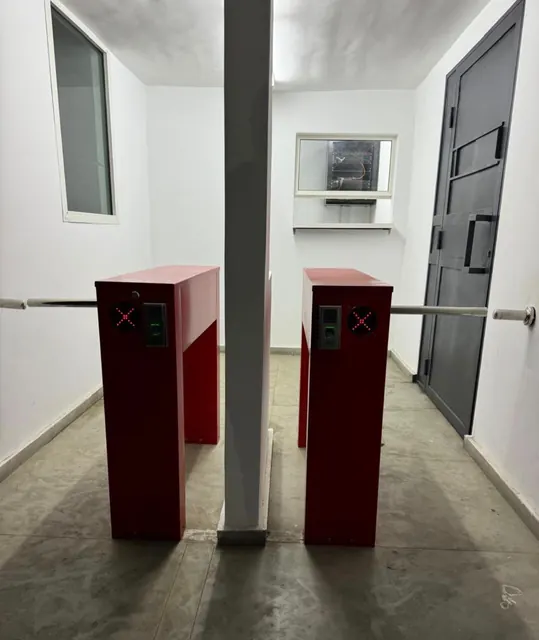 Sas d'entrée équipé de deux tourniquets tripodes à lecteur d'empreinte digitale.