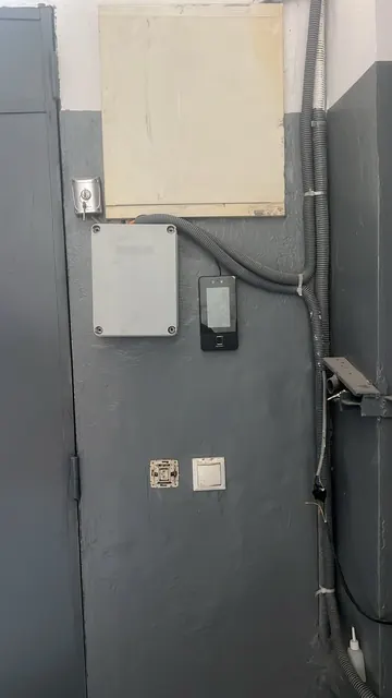 Terminal facial près d'un accès technique, à côté du coffret de commande d'un portail.