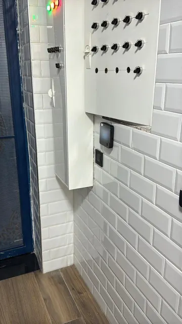 Terminal facial près d'un poste de service, sur un mur carrelé.
